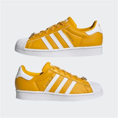 Weiße, gelbe adidas Superstar 